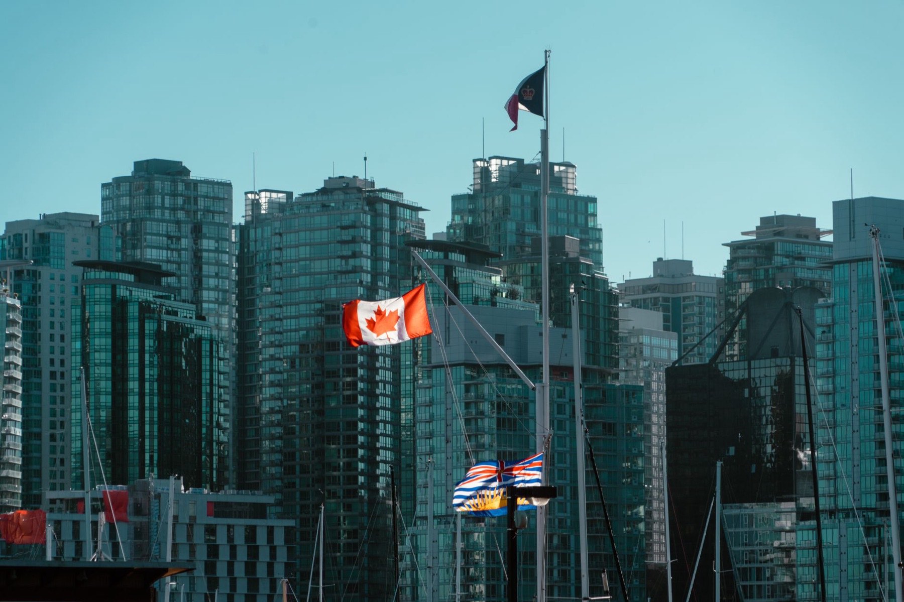 British Columbia and Canadian flags in front of the Vancouver skyline